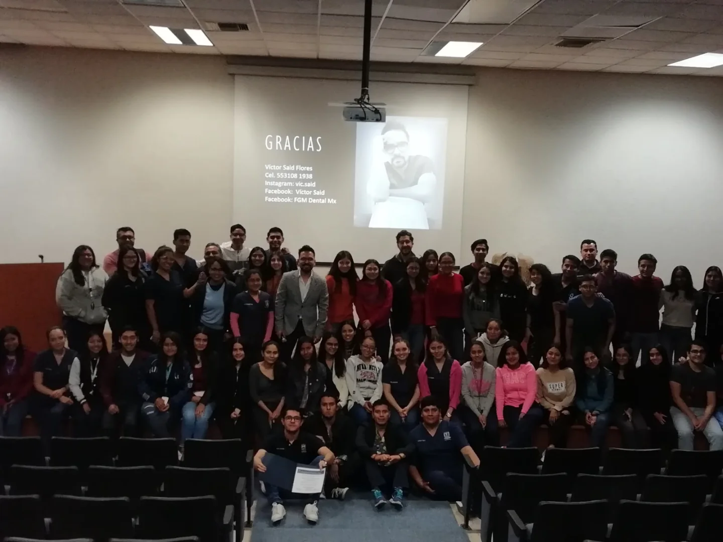 Grupo de estudiantes y asistentes reunidos al finalizar una conferencia de odontología